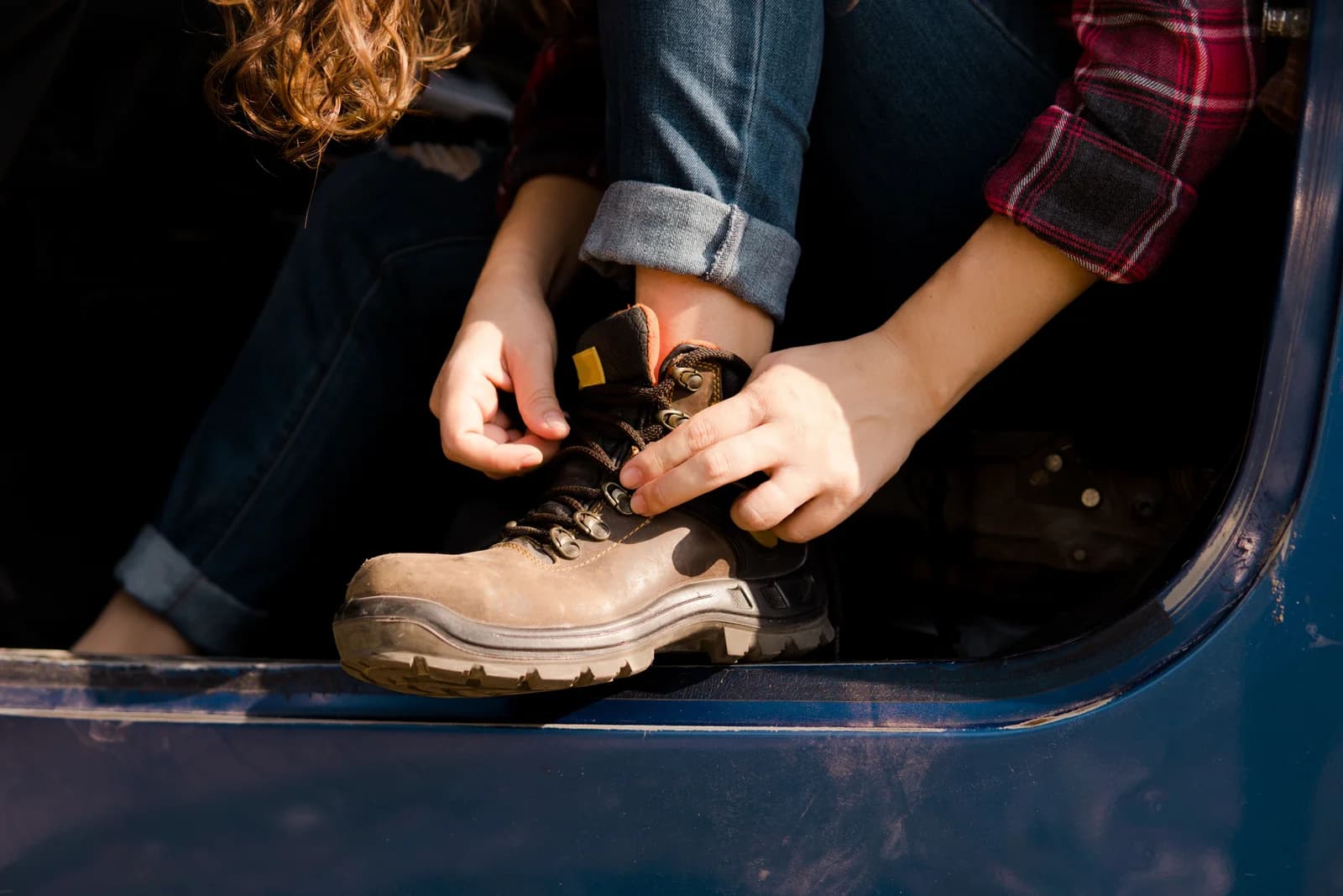 Persona ajustando los cordones de una bota de trabajo antes de usarla