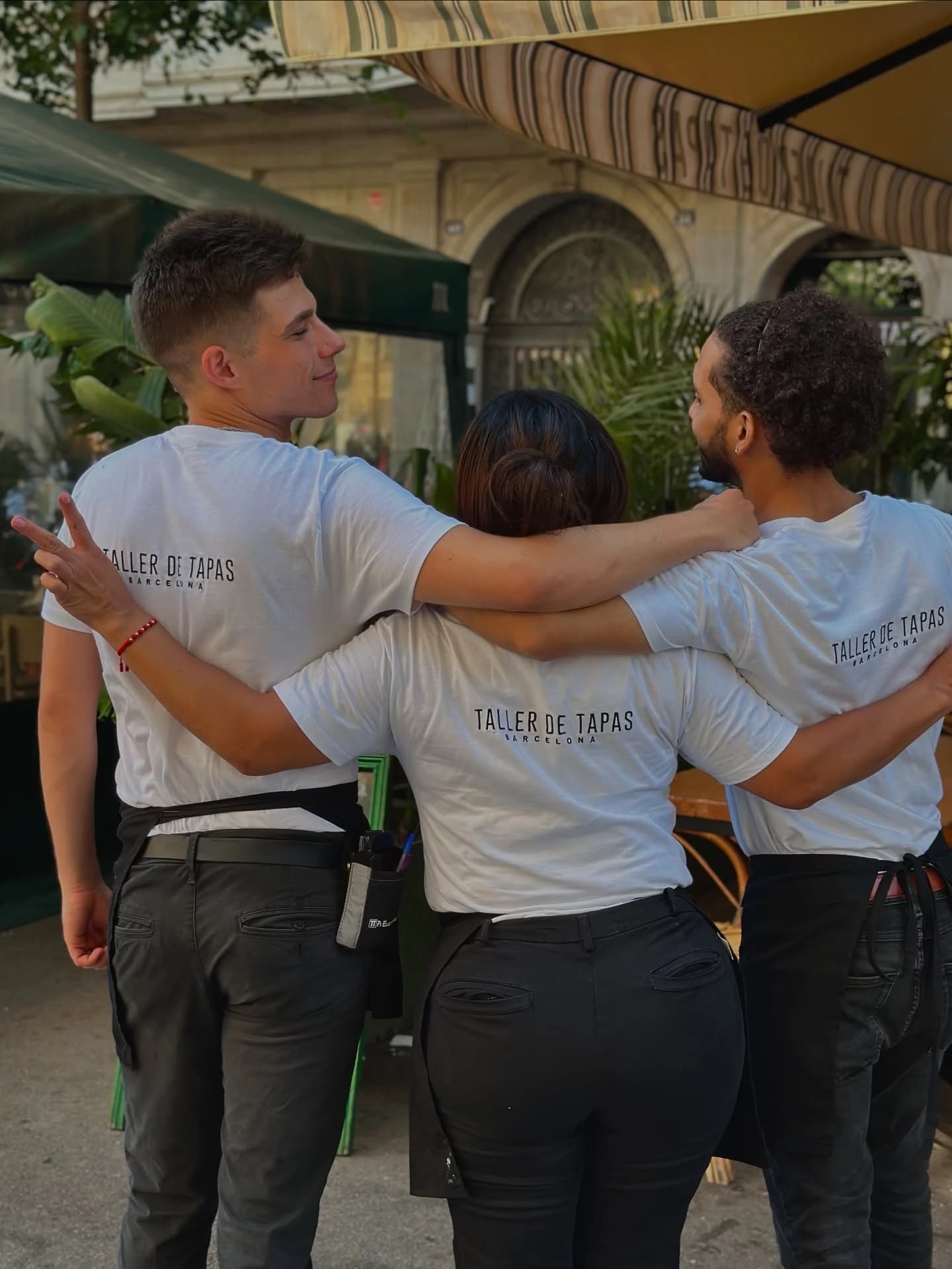 Taller de Tapas team wearing white T-shirts customised on the back and dark aprons